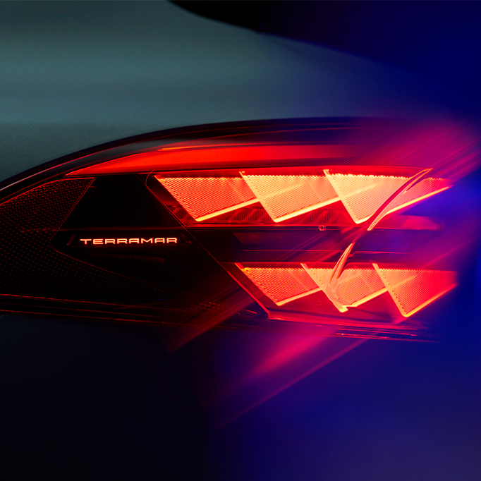 cupra terramar close-up of rear taillight with illuminated model name, showing distinctive red triangular light pattern against dark background