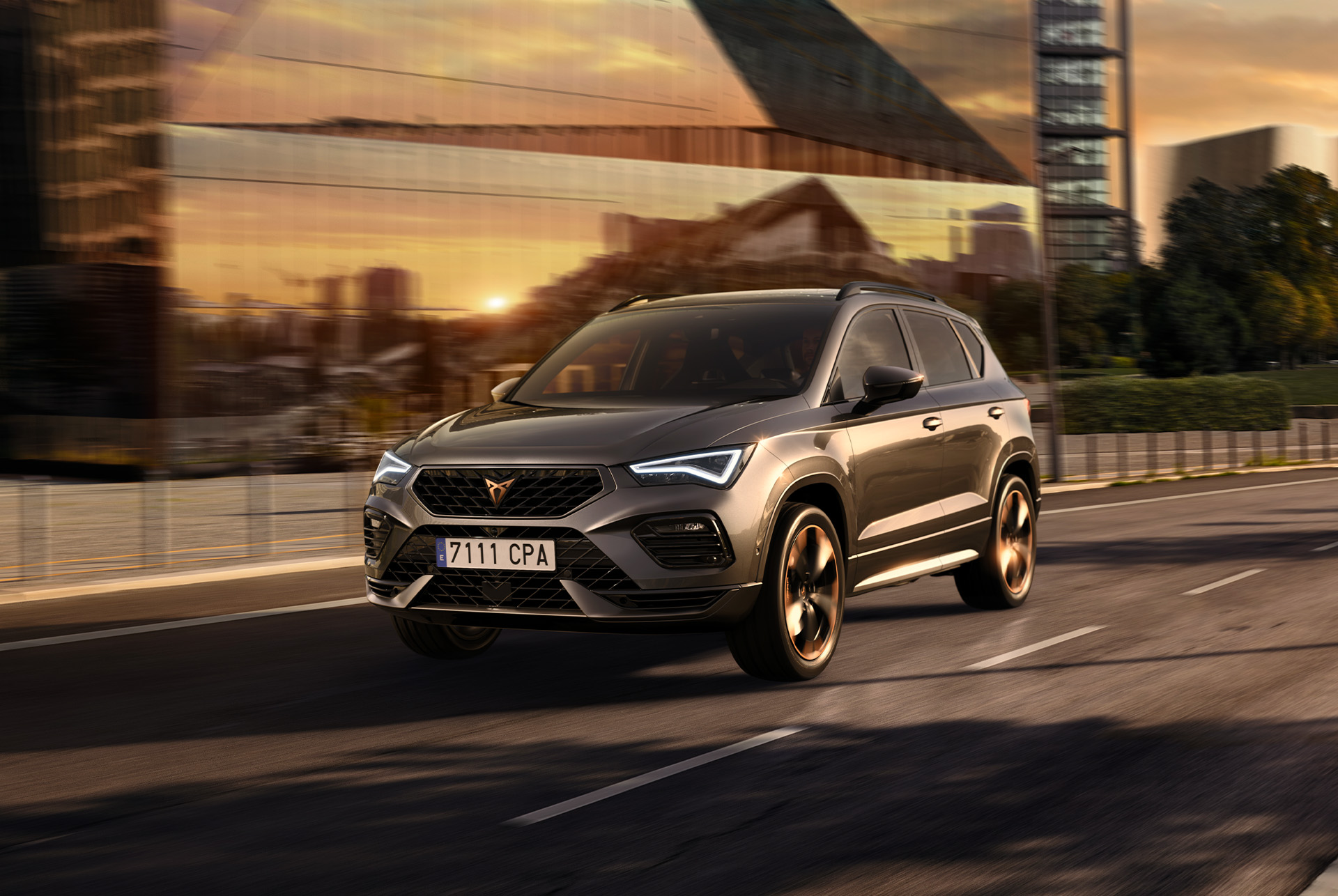 Le SUV CUPRA Ateca sur une route urbaine au coucher du soleil. Le SUV est disponible avec une motorisation 150ch en traction avant, ce qui permet de réduire les émissions et la consommation de carburant. 