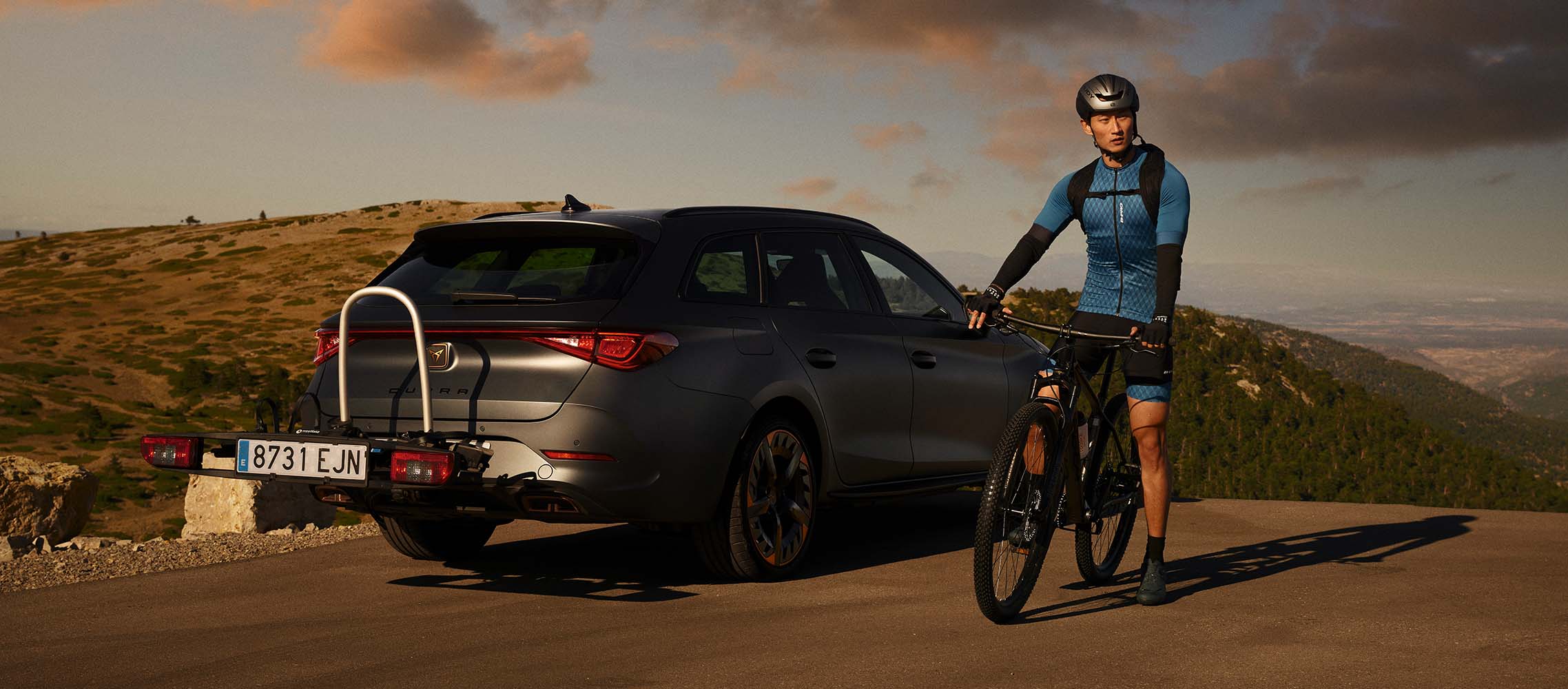 Homme en vélo à côté de CUPRA Leon