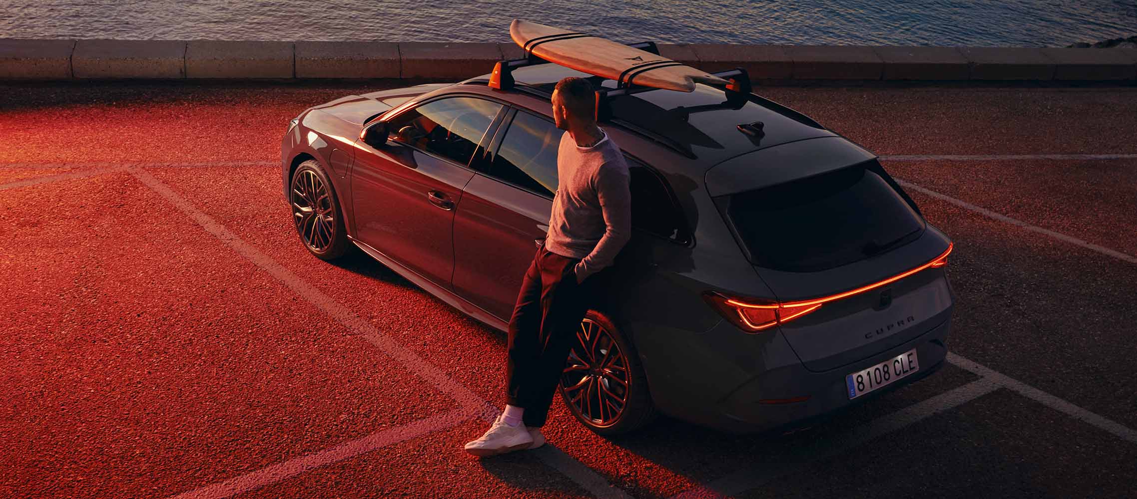 homme à côté de CUPRA Leon avec porte-surf