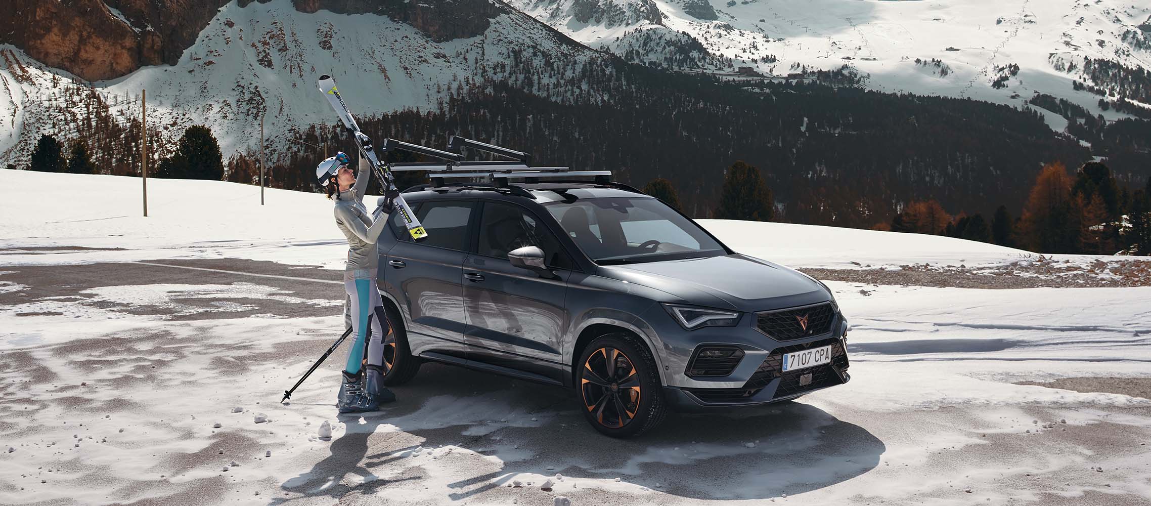 Femme posant ses skis sur le toit de son CUPRA Ateca